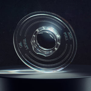Clear plastic hub cap sight glass on a black pedestal against a dark background