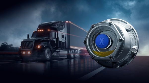 Truck on a road with a close-up of The Xtractor hub cap against a dark sky.